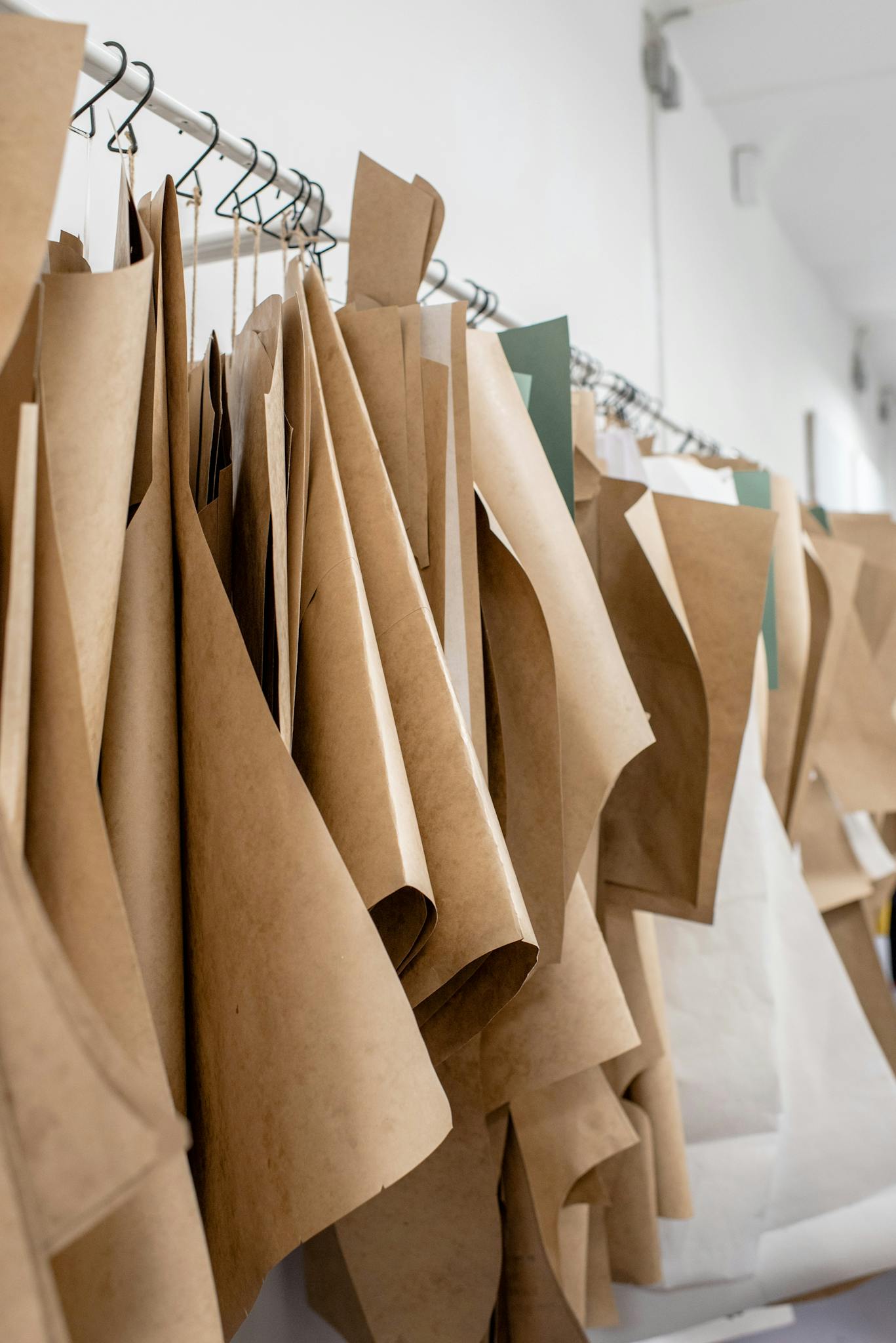 A collection of paper sewing patterns hanging in a bright fashion studio interior.