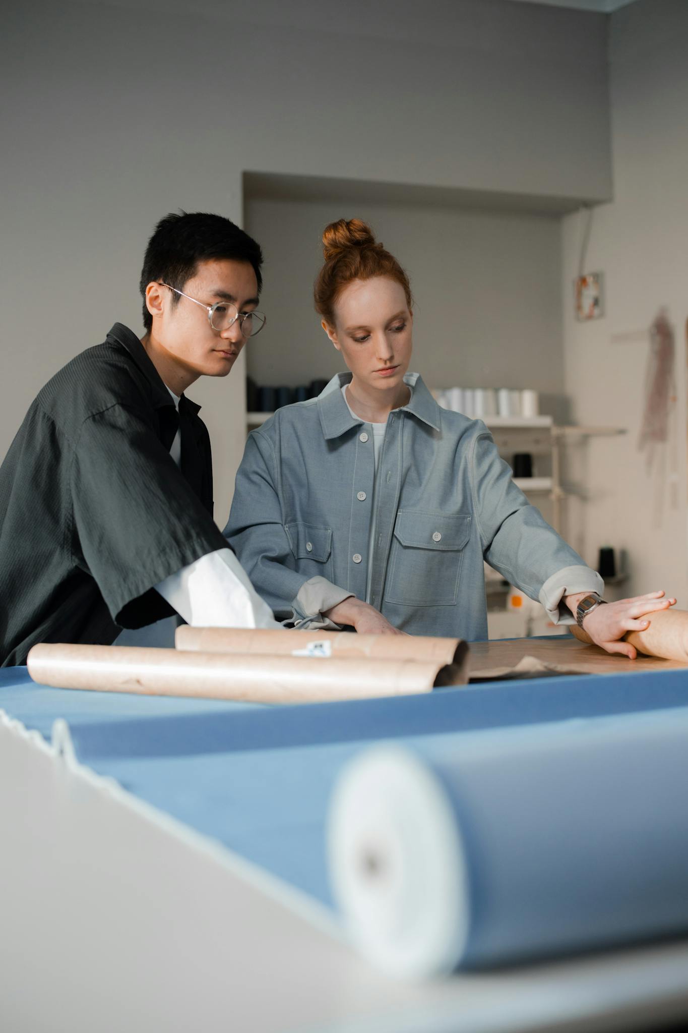 Two fashion designers working on dressmaking in a modern studio.